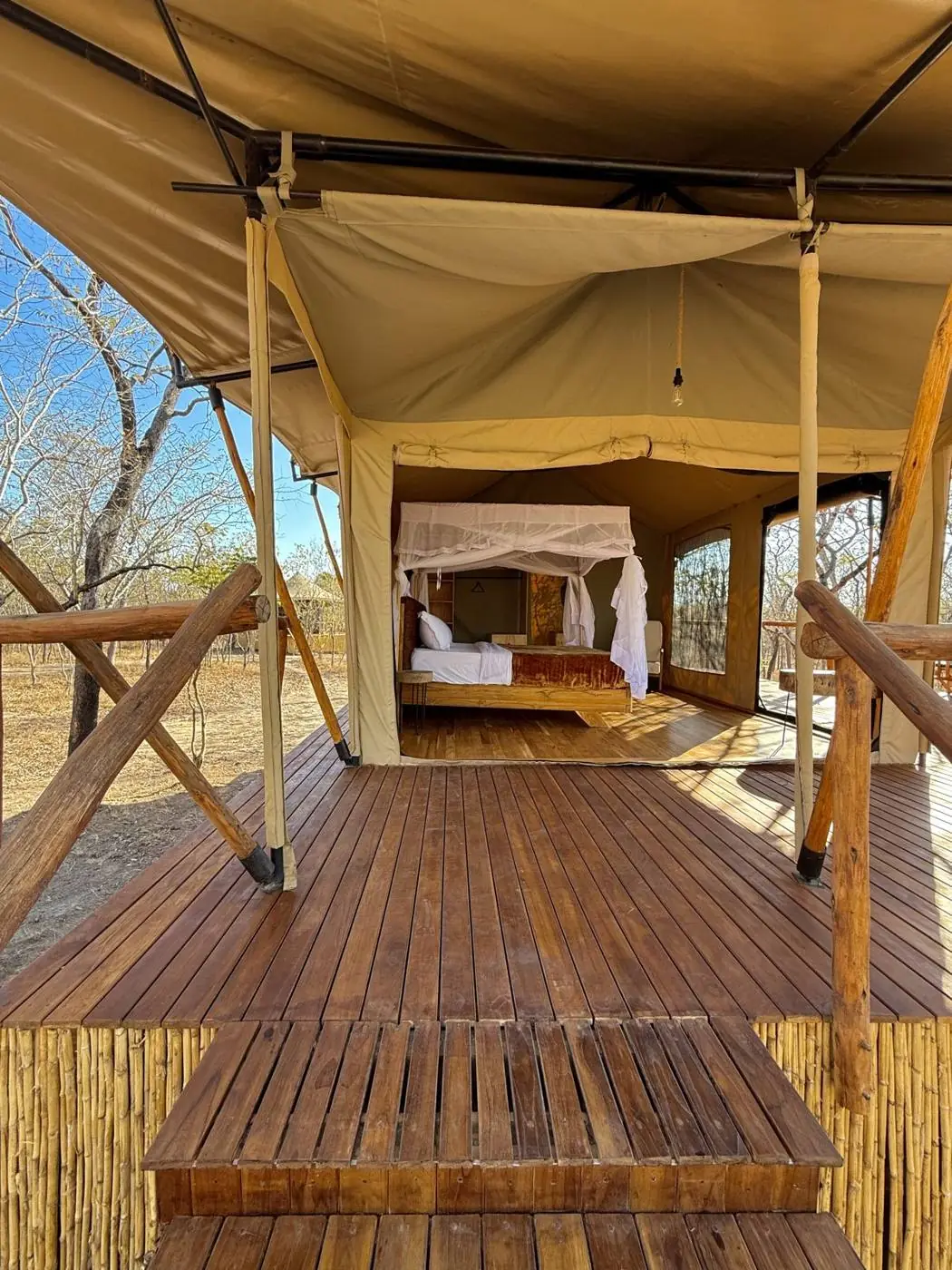 Luxury safari tent at Camp Lilac on a raised wooden deck under the trees near Mikumi National Park
