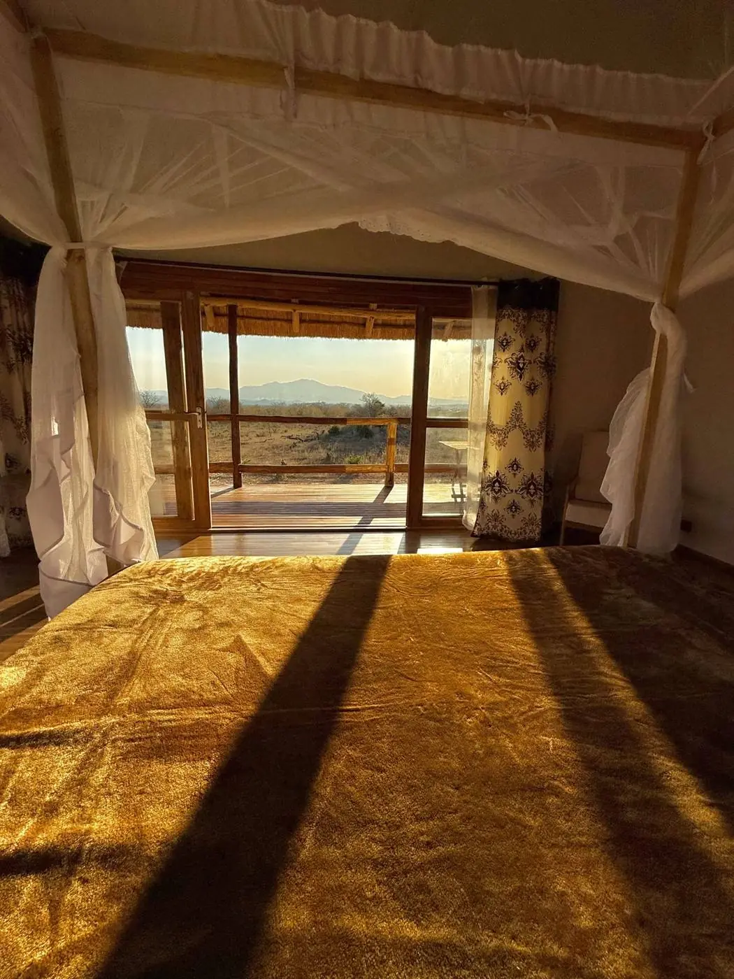 Sunrise light falling across the four-poster bed in the Mountain View Cabin